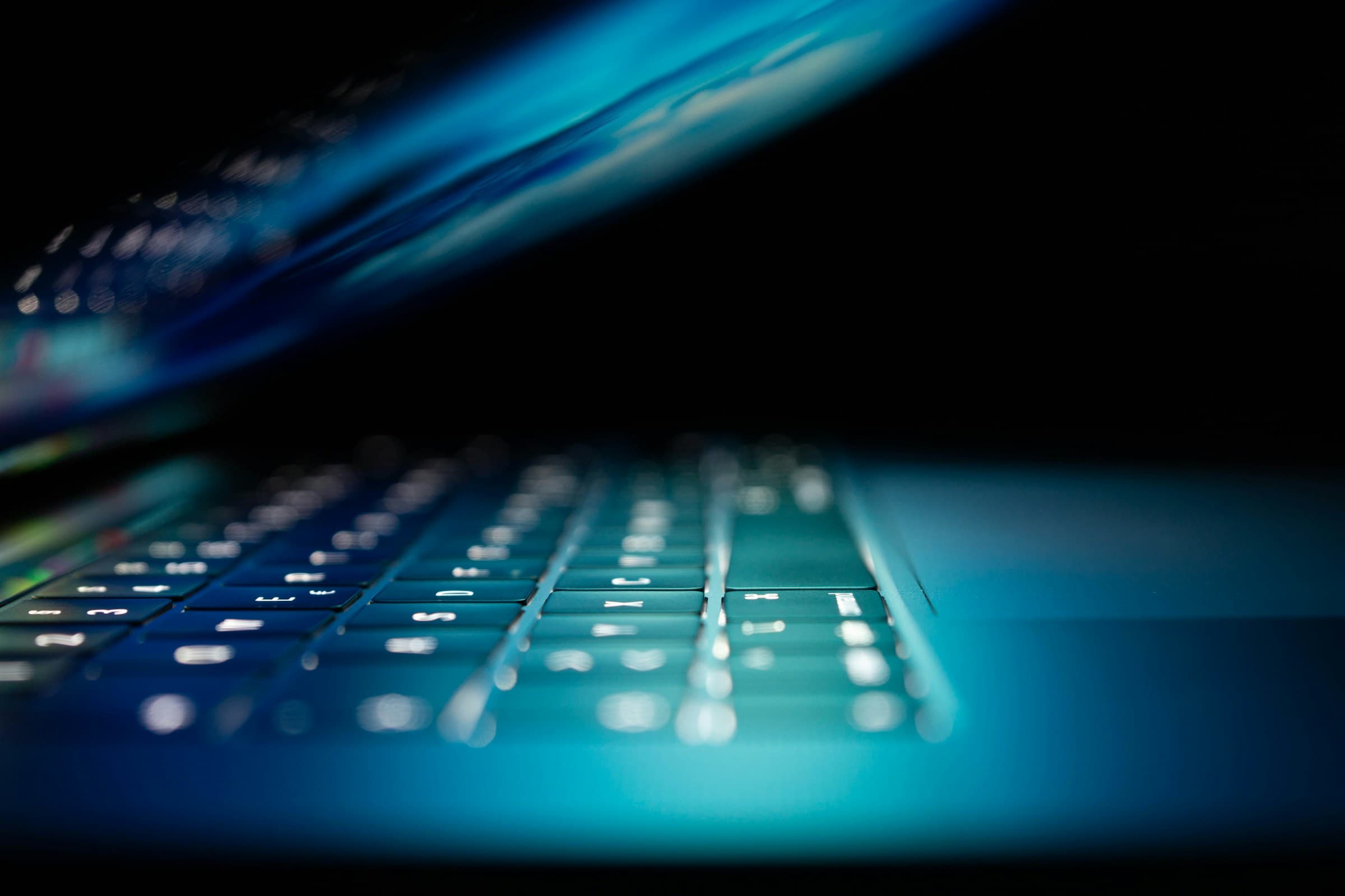 Close-up of a laptop with blue cybersecurity-themed lighting